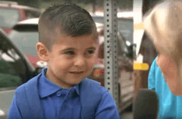 Shows a boy asked by a reporter to answer a question. He is initially happy but soon starts crying.